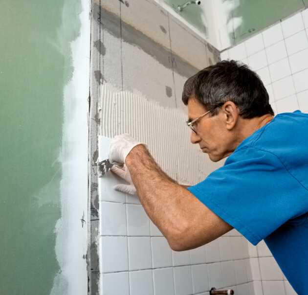 Worker remodeling a tile wall